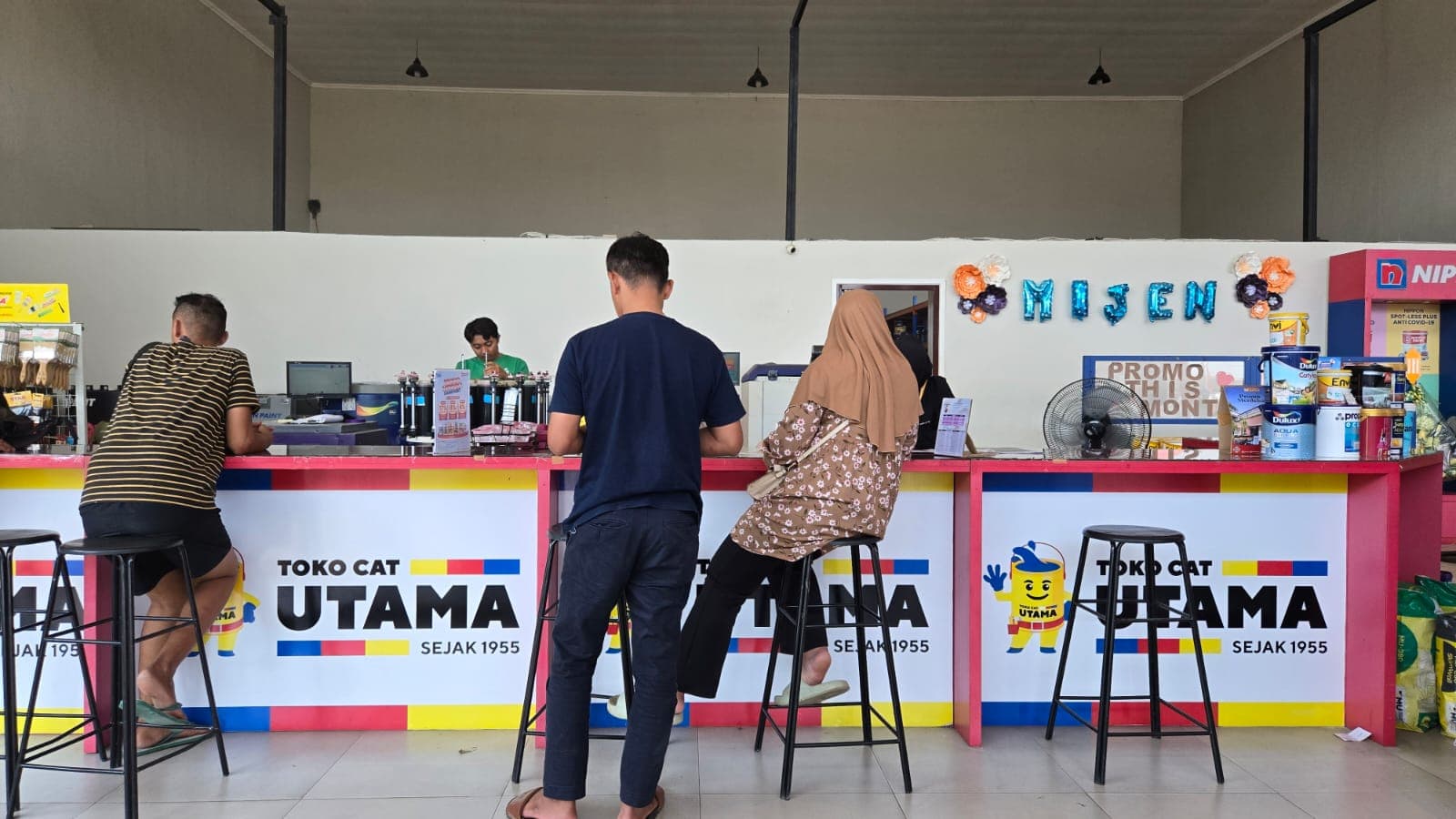 Pelanggan sedang dilayani di meja konsultasi Toko Cat Utama